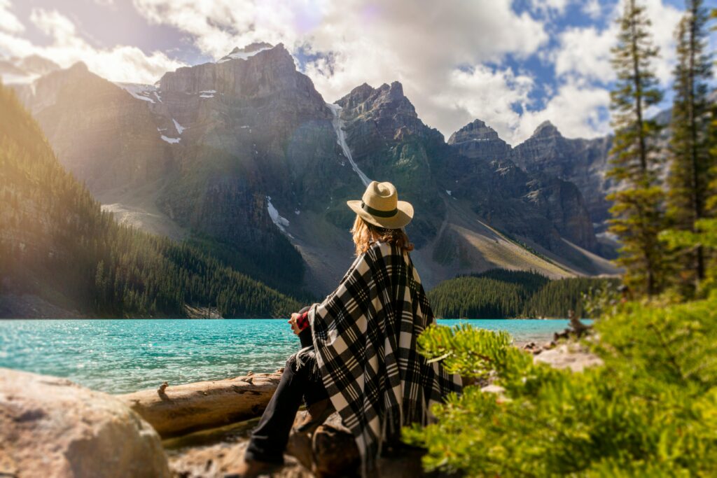 Woman prioritising her personal growth and self-improvement by sat meditating on a mountain